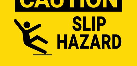 Black text on bright yellow sign,
Caution, slip hazard,
with stick figure falling backwards.