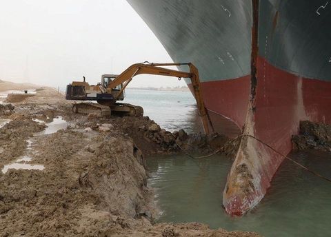 A back hoe on the bank of the Suez, trying to free the Ever Given cargo ship